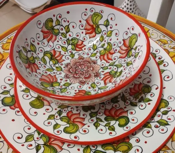 Cecilia Bella pasta bowl, salad and dinner plates arranged on a table. Each piece is hand-painted by Andrilia in Deruta