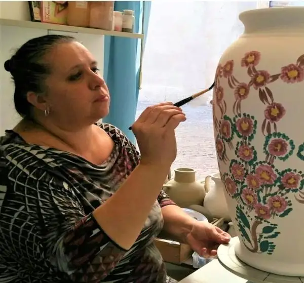 La Corte dei Gonzaga painting a large ceramic umbrella stand in her artist's studio in Mantua, Italy